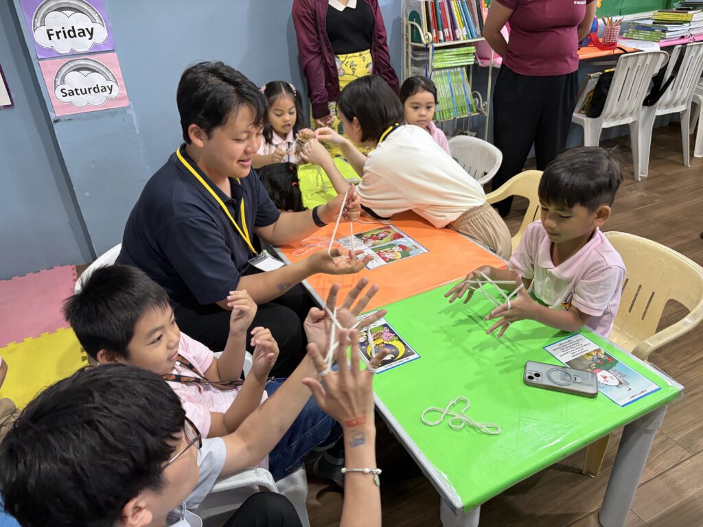 小学1・2年生にあやとりの授業を行っている様子